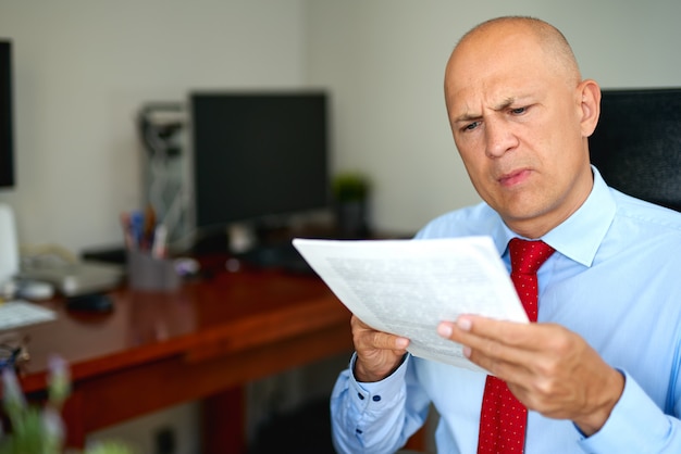 Foto hombre de camisa azul y corbata roja en la oficina