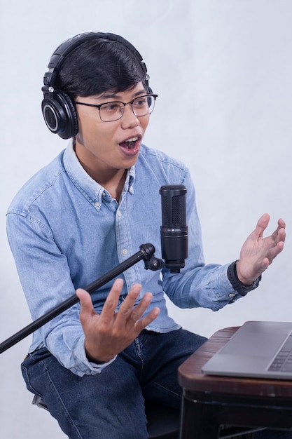 Foto un hombre con una camisa azul habla por un micrófono con un micrófono.