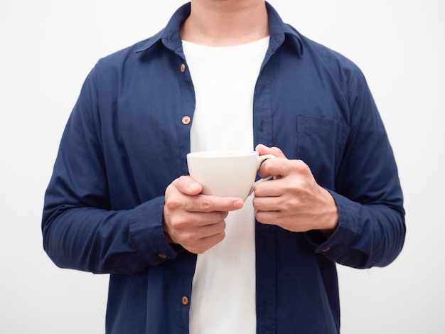 Hombre camisa azul sosteniendo la taza de café cosecha tiro fondo blanco.