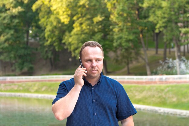 Hombre de camisa azul usa su teléfono inteligente