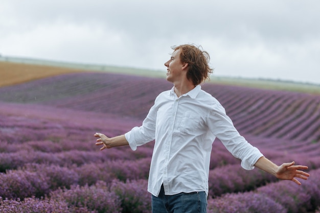 Un hombre con una camisa blanca en un campo de lavanda