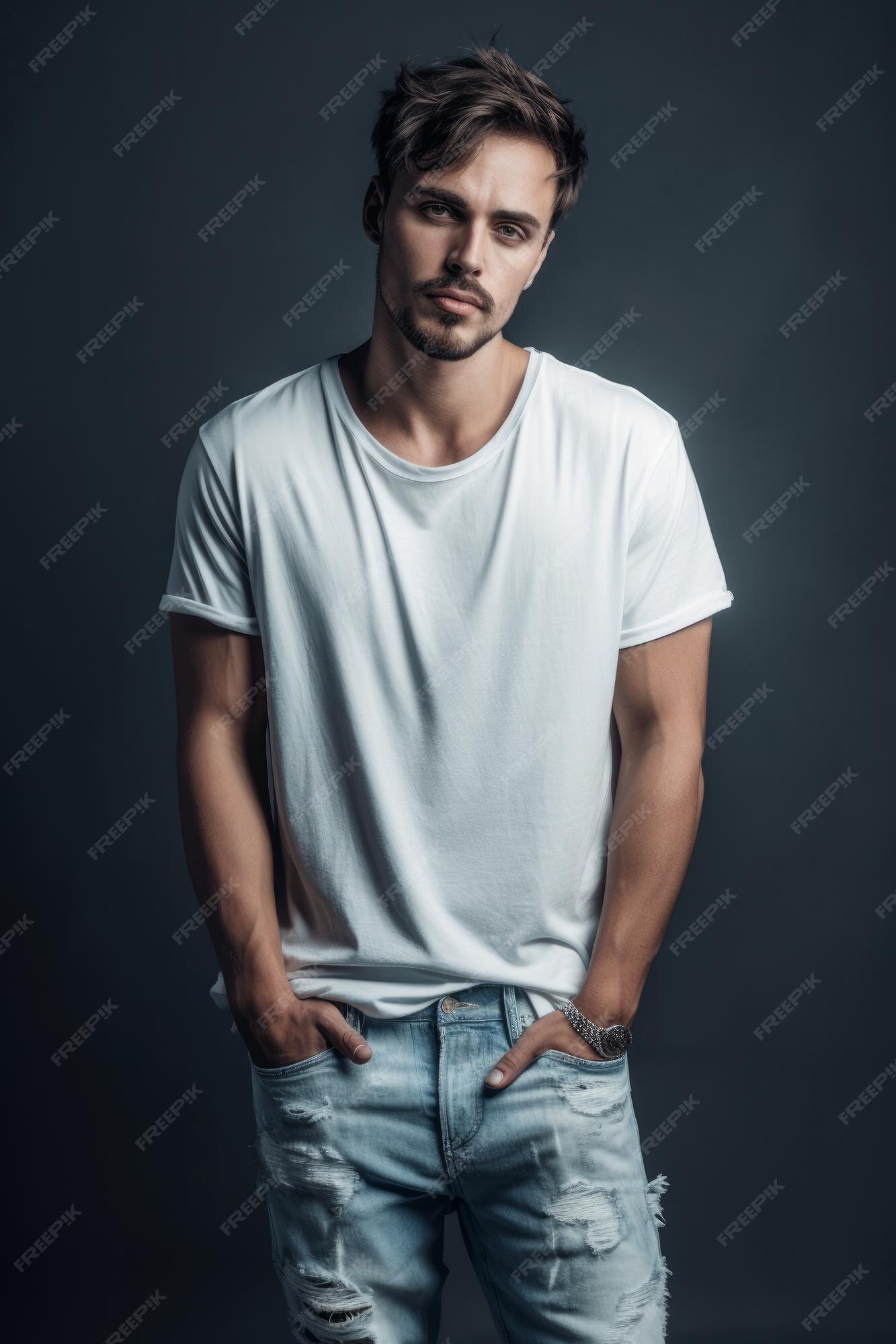 Un hombre con una camisa blanca y jeans se para en un estudio. | Foto