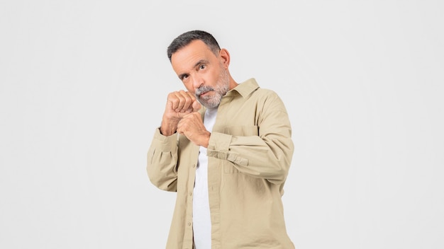 Hombre con camisa bronceada sosteniendo las manos en una postura de lucha