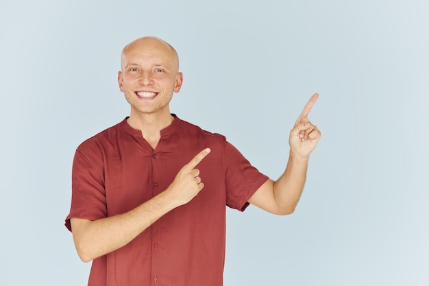 El hombre con camisa casual roja está de pie contra el fondo blanco