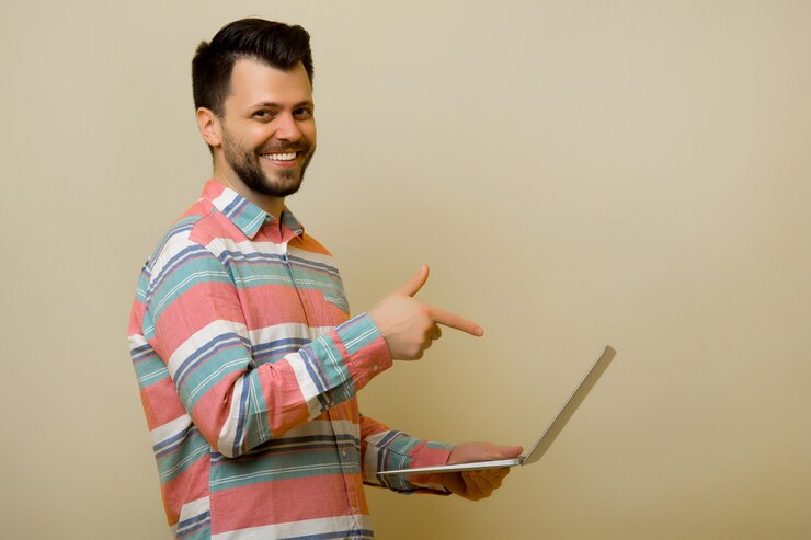 Foto hombre en camisa casual sosteniendo portátil plateado