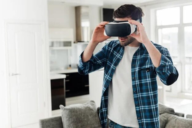 Hombre con camisa a cuadros usando auriculares de realidad virtual en casa