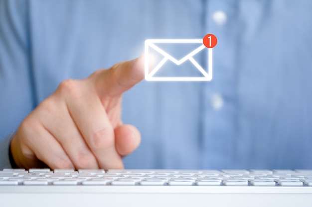 Un hombre con una camisa delante del teclado. Icono de correo electrónico abstracto con nuevo mensaje. Concepto de retroalimentación de internet.