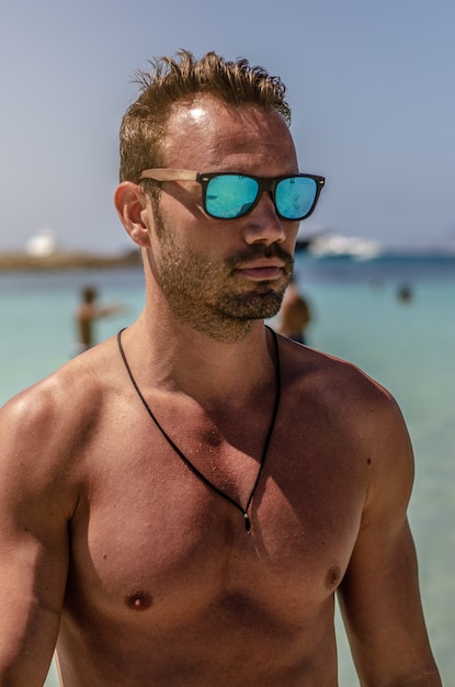 Hombre sin camisa disfrutando de la playa