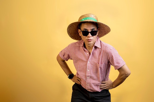 Hombre con una camisa con gafas de sol y un sombrero de pie