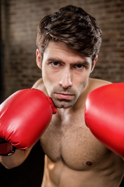 Hombre sin camisa con guantes de boxeo