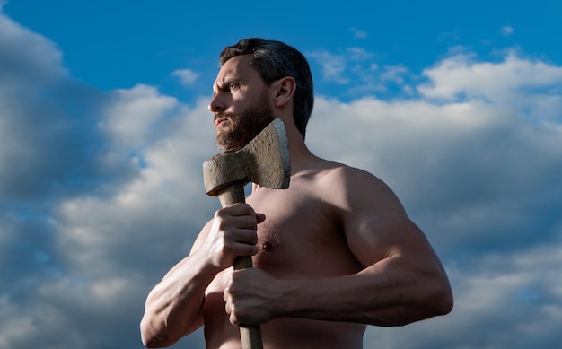 Hombre sin camisa con hacha leñador hombre sostenga hacha brutal hombre sobre fondo de cielo