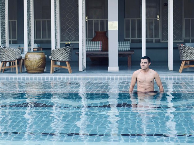 Foto hombre sin camisa en la piscina