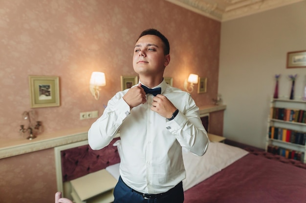 Un hombre con camisa se pone una pajarita