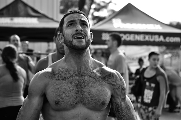 Hombre sin camisa preocupado mirando hacia arriba en el carnaval