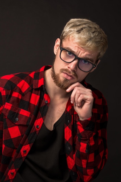 Hombre de camisa roja en jaula con gafas sobre fondo negro