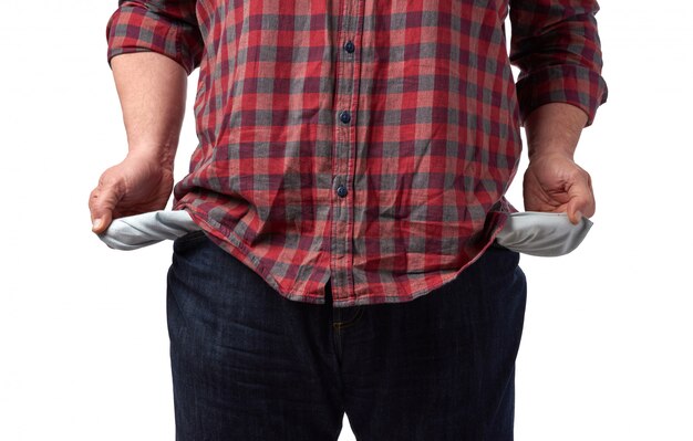 El hombre con una camisa roja sacó los bolsillos vacíos de sus pantalones