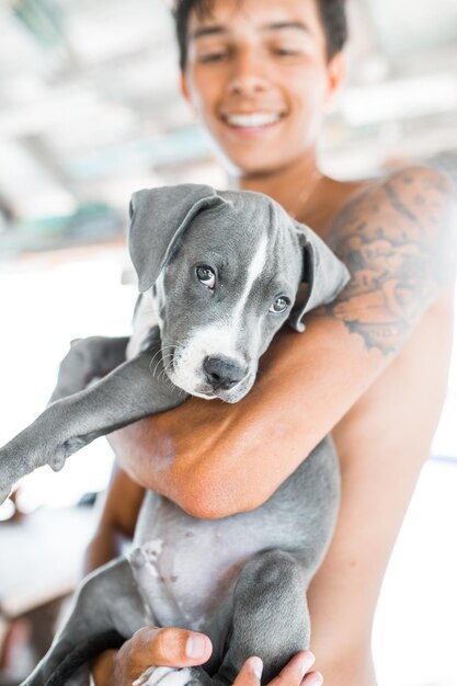 Hombre sin camisa sonriente de pie con el perro