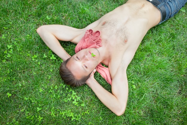 Hombre sin camisa tirado en el pasto