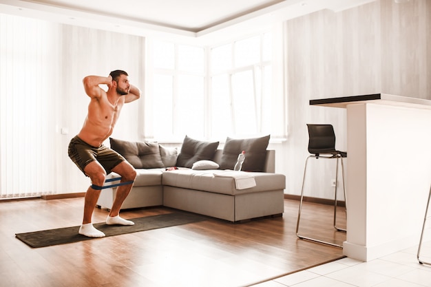 Hombre sin camisa trabajando en casa