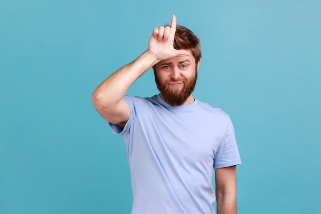 El hombre de camiseta azul que muestra un gesto más flojo sostiene los dedos cerca de la frente triste por un error tonto