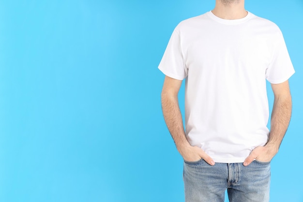 Hombre en camiseta blanca en blanco sobre fondo azul.