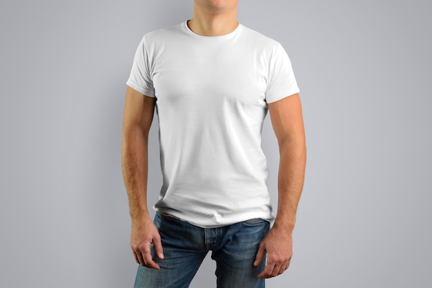 El hombre con una camiseta blanca está aislado en una pared gris