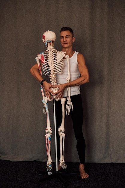 Foto un hombre con una camiseta blanca estudia la estructura del esqueleto humano