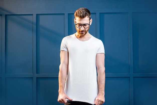 Hombre de camiseta blanca sobre fondo azul