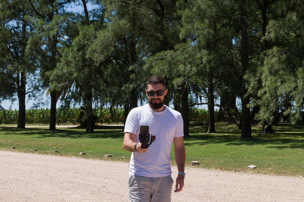 Foto hombre con camiseta blanca sosteniendo un cardán