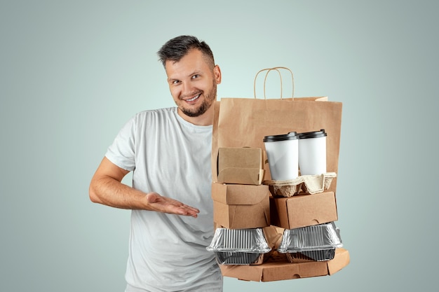 Hombre en una camiseta brillante dando un pedido de comida rápida aislado sobre un fondo azul.