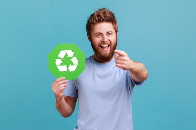 Hombre en camiseta con cartel de reciclaje verde salvando el concepto de ecología ambiental apuntando a la cámara