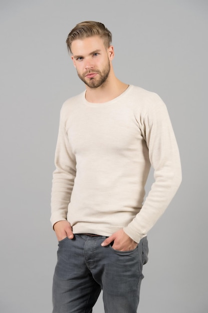 Hombre en camiseta casual y jeans Macho con barba en la cara sin afeitar Hombre barbudo con las manos en los bolsillos Concepto de confianza y carisma Estilo de moda y tendencia