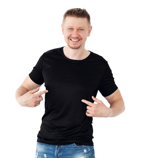 Hombre con una camiseta negra aislado en un fondo blanco apuntando con el dedo en blanco para tu diseño