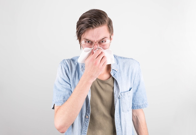 Hombre en camiseta con secreción nasal en blanco