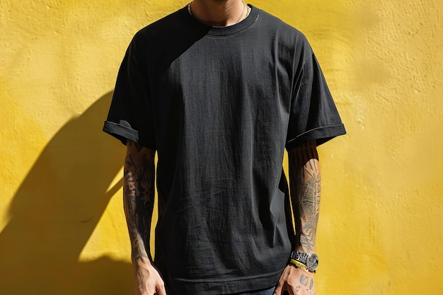 Un hombre con una camiseta de tamaño grande negra sin texto o diseño en la camisa de pie en frente