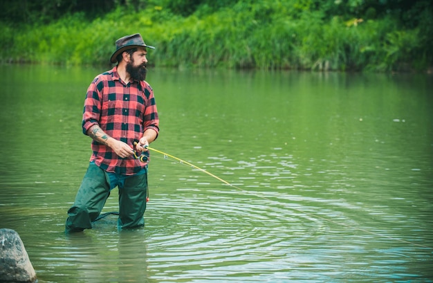 Foto hombre con caña de pesca pescador hombres en el agua del río al aire libre afición de pesca de verano