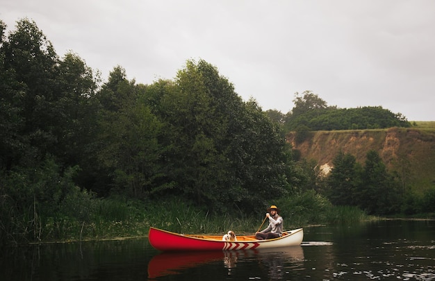 Hombre en canoa con su perro en un hermoso parque natural en el río