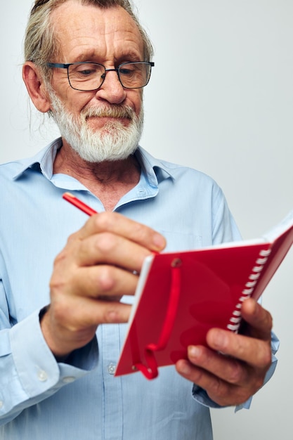 El hombre canoso mayor escribe emociones en un cuaderno inalterado