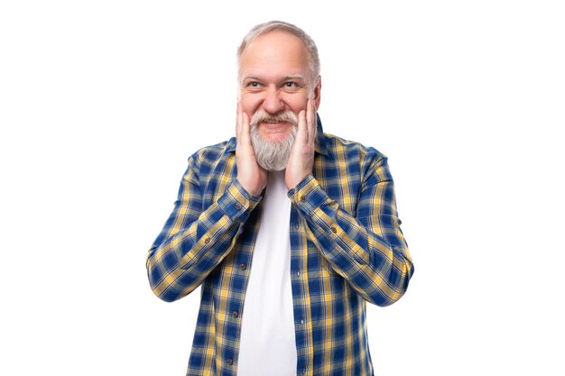 Un hombre canoso de mediana edad sonriente con barba en una camisa sobre un fondo blanco