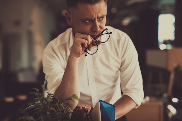 Hombre cansado dejar el lugar de trabajo con caja de oficina.