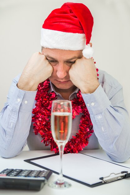 hombre cansado durmiendo en la mesa en la oficina en la noche de Navidad. Hombre de negocios celebrar Feliz Navidad y Feliz Año Nuevo desgaste Santa Hat