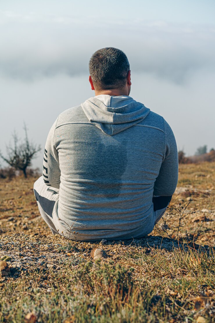 Foto hombre cansado excursionista se sienta en una montaña y se relaja