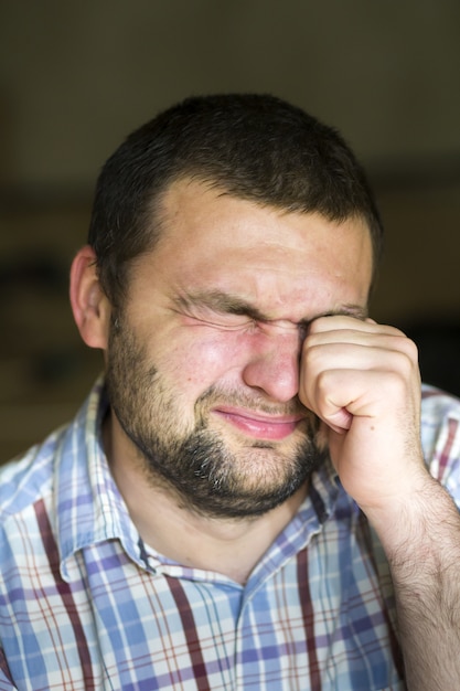 Foto hombre cansado frotándose los ojos