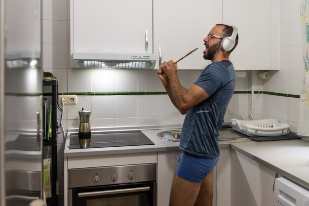 Hombre cantando mientras lava los platos