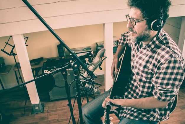 Foto hombre cantando mientras toca la guitarra