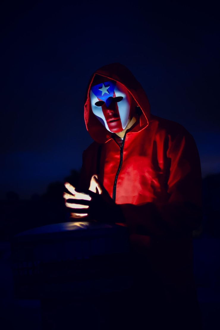 Foto hombre con capucha y máscara contra el cielo por la noche
