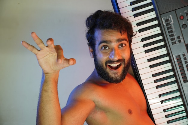 Hombre de cara feliz con piano electrónico