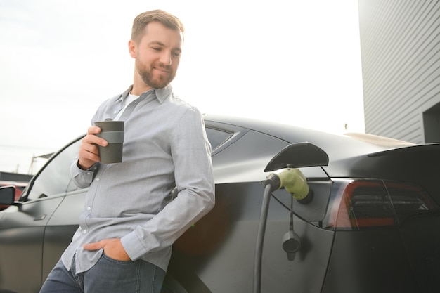 un hombre carga un coche eléctrico