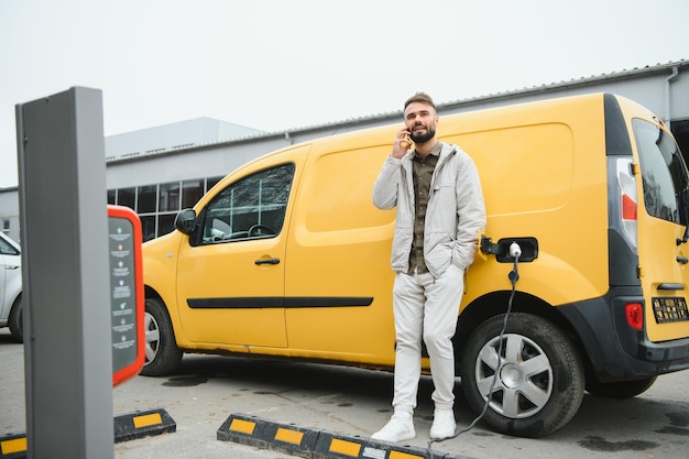 Hombre cargando coche eléctrico por el trabajo.