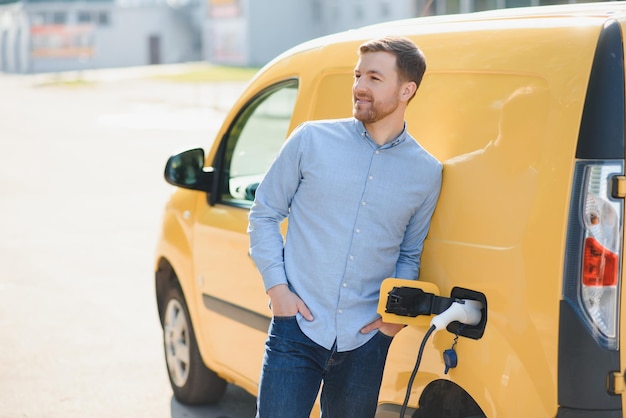 Hombre cargando su coche eléctrico en la estación de carga